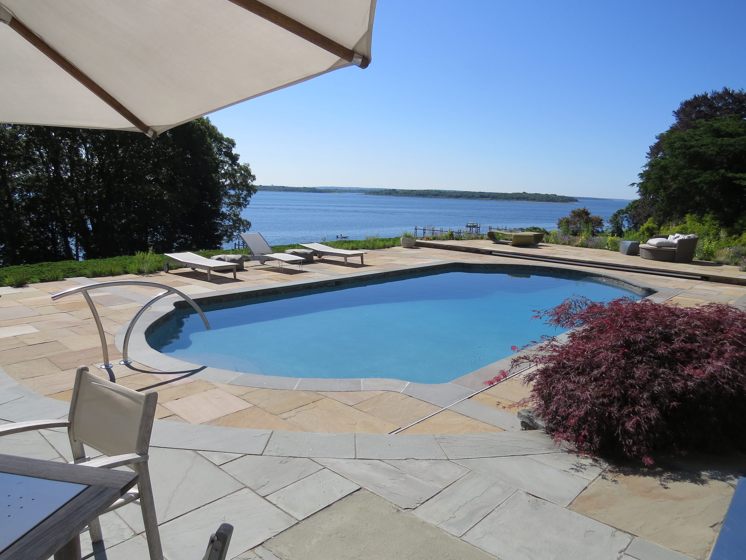 Portfolio A freeform pool on a bluestone terrace overlooking the bay
